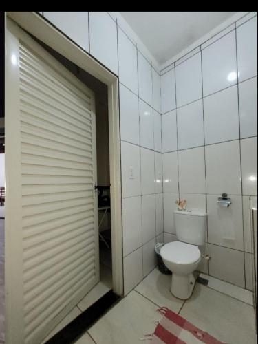 a bathroom with a toilet and a closed door at Recanto Fernanda in Olímpia