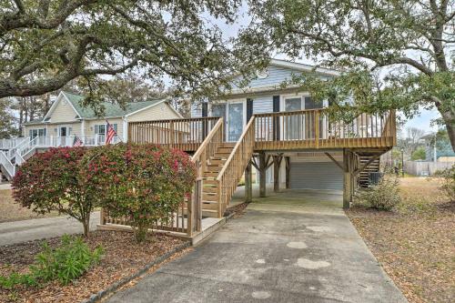 a house with a wooden deck with a porch at Cozy Oak Island House Less Than 1 Mi to Beaches! in Oak Island
