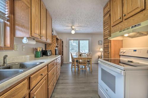 a kitchen with wooden cabinets and a table with chairs at Cozy Oak Island House Less Than 1 Mi to Beaches! in Oak Island