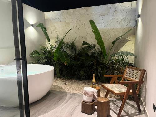 ein Badezimmer mit einer großen Badewanne und Pflanzen in der Unterkunft suite U24 de lujo en chaac tulum in Tulum