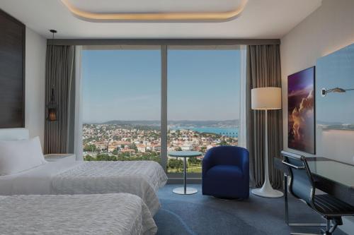a hotel room with two beds and a large window at Le Meridien Istanbul Etiler in Istanbul