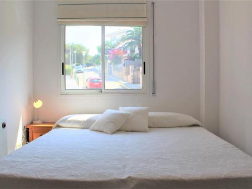 - une chambre avec un lit blanc et une fenêtre dans l'établissement Apartamento Llançà, 2 dormitorios, 5 personas - ES-228-63, à Llançà