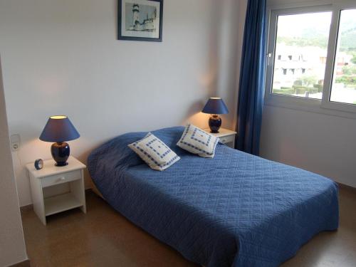 ein Schlafzimmer mit einem blauen Bett mit zwei Lampen an Tischen in der Unterkunft Apartamento Llançà, 3 dormitorios, 6 personas - ES-228-84 in Llança