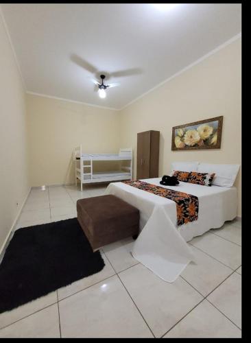 a bedroom with a bed and a table in it at Recanto Fernanda in Olímpia