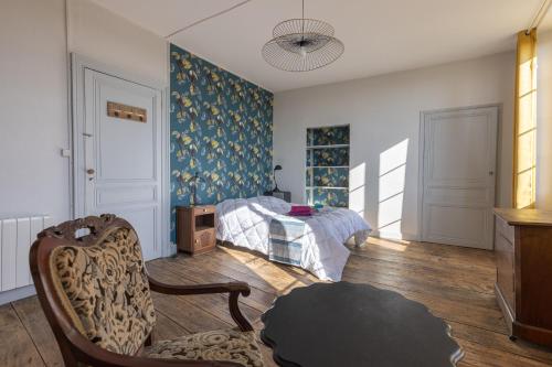 1 dormitorio con 1 cama y 1 silla en LaConciergerieJonzac, Maison Côté Vintage avec jardin, en Jonzac