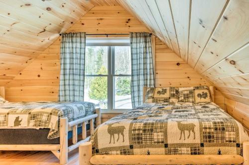 um quarto com 2 camas num chalé de madeira em Maine Cabin Rental on Rangeley Lake! em Rangeley