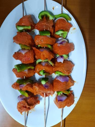 a white plate with some food on tooth picks at Aaravi Garden Homestay in Kalimpong