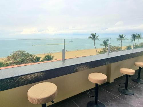 a bar with stools and a view of the beach at Happy Jomtien - Direct Beach Access, Sea View & Central Location in Jomtien Beach