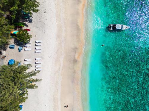 an overhead view of a beach with a boat in the water at Bale Sampan Boutique Bungalows in Gili Trawangan