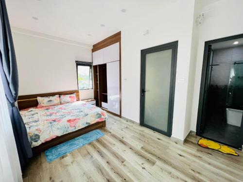 a bedroom with a bed and a large window at HomeTa Homestay in Bao Loc