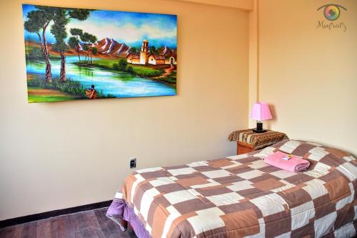 1 dormitorio con 1 cama y una pintura en la pared en solsticio hostel, en Copacabana