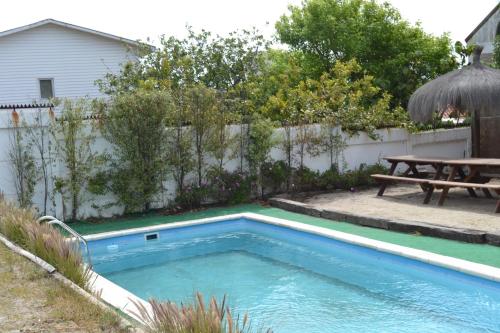 a small swimming pool in a backyard with a picnic table at Linda Vista Apart Hotel in Concón