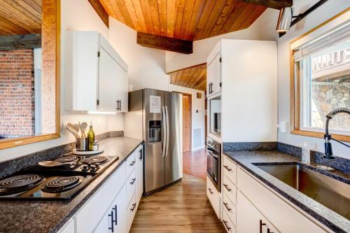 a kitchen with white cabinets and wooden ceilings at Ocean Vista Gold Beach Getaway! in Gold Beach