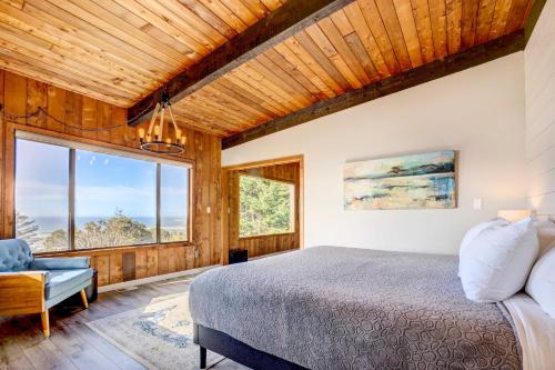 a bedroom with a bed and a large window at Ocean Vista Gold Beach Getaway! in Gold Beach