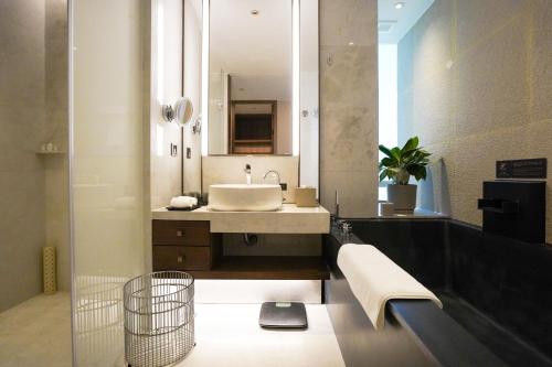 a bathroom with a sink and a large mirror at Empark Grand Hotel Fuzhou in Fuzhou