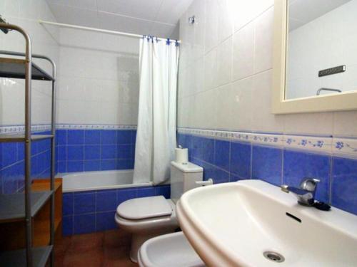uma casa de banho azul e branca com um WC e um lavatório em Apartamento Roses, 1 dormitorio, 4 personas - ES-228-125 em Roses
