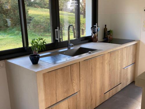 une cuisine avec un évier et une fenêtre dans l'établissement Maison lumineuse en pleine nature, 800 m de la mer, proche plage, jardin, WiFi, tout équipé. - FR-1-418-229, à Locmaria