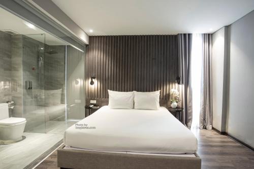 a bedroom with a large bed and a shower at Grand Ocean Luxury Boutique - Infinity Rooftop Pool in Da Nang