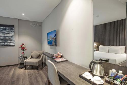 a hotel room with a bed and a desk and a room at Grand Ocean Luxury Boutique - Infinity Rooftop Pool in Da Nang