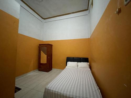 ein Schlafzimmer mit einem Bett in der Ecke eines Zimmers in der Unterkunft SPOT ON 92362 Pondokan Tali Super in Parepare
