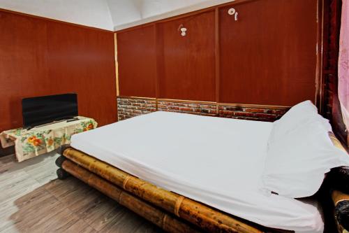 龍目島的住宿－OYO 92354 Samalas Syariah Homestay，木墙客房的一张床位
