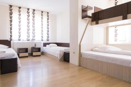 a room with two beds and a tv in it at Hostel Holland Bacau in Bacău