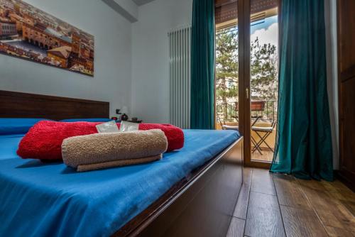 a bedroom with a bed with blue sheets and red pillows at B&B Selvarossa in Bologna