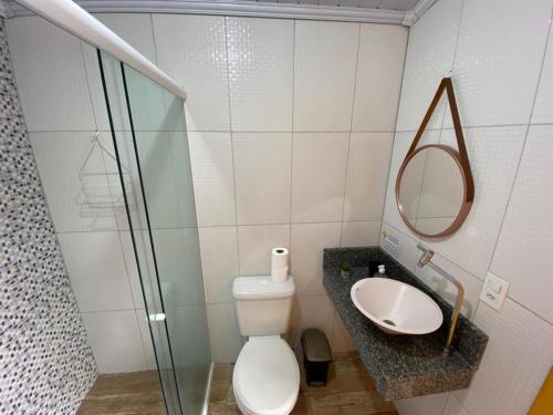 ein Badezimmer mit einem WC, einem Waschbecken und einem Spiegel in der Unterkunft Casa Aconchegante Paraty in Paraty