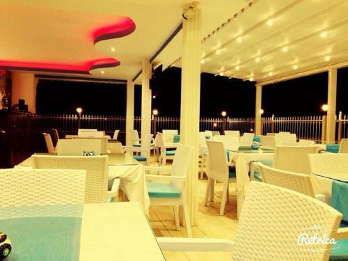 a restaurant with white tables and white chairs at Aura Boutique Hotel in Side