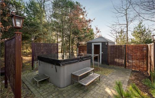 Nørre NebelにあるThree-Bedroom Holiday Home In Norre Nebelの裏庭のホットタブ(フェンス付)