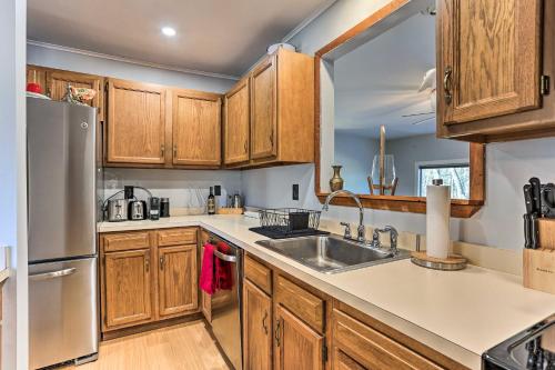 a kitchen with wooden cabinets and a sink at Game Room, Fire Pit Family-Friendly Poconos Haven in East Stroudsburg