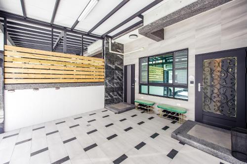 a room with a door and two stools at 綠舍睡到民宿 in Taitung City