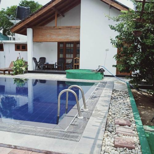 a house with a swimming pool in front of a house at Bella Nilaveli Beach in Nilaveli