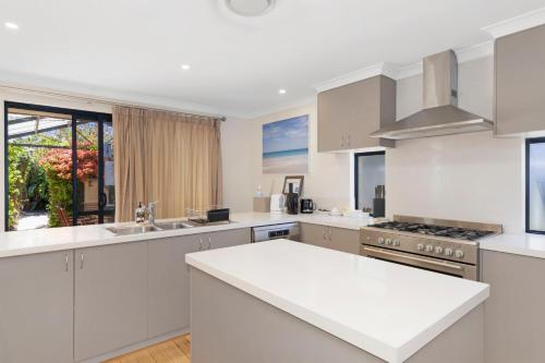 a kitchen with white cabinets and a white counter top at Baudins of Busselton Bed and Breakfast - Adults only in Busselton