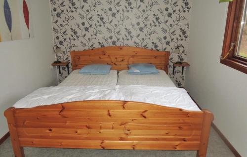 a wooden bed with two blue pillows on it at Awesome Home In Torup With 2 Bedrooms in Kragared