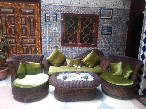 a living room with chairs and a couch and a table at Ryad Bab Berdaine in Meknès
