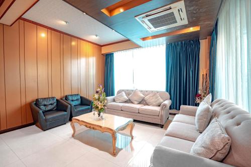 a living room with a couch and a table at Blue Sky Residence Airport in Ban Bang Phli Yai
