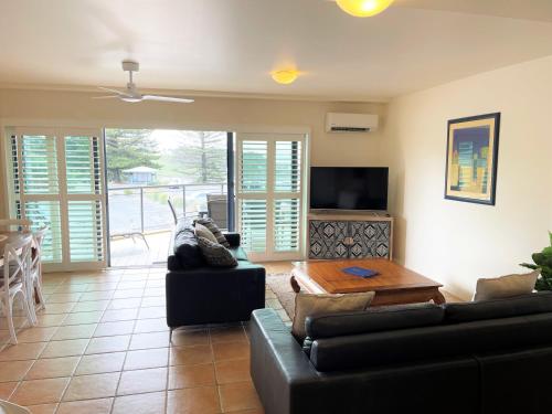 a living room with a couch and a table at The Cove Yamba in Yamba