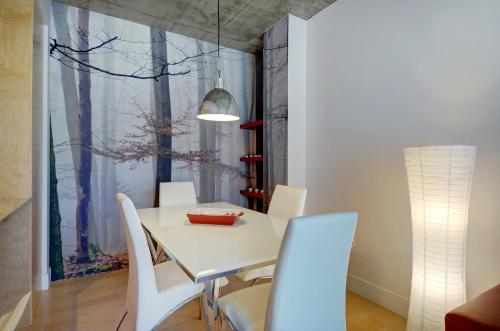 a dining room with a white table and white chairs at Les Immeubles Charlevoix - Le 760204 in Quebec City