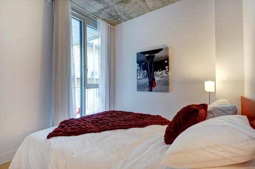 Un dormitorio con una cama con una manta roja. en Les Immeubles Charlevoix - Le 760204 en Quebec