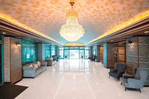 a lobby with a chandelier and chairs in a building at Blue Sky Residence Airport in Ban Bang Phli Yai