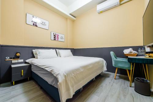 a hotel room with a bed and a desk and a bed sidx sidx at 綠舍睡到民宿 in Taitung City
