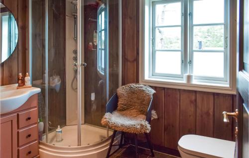 a bathroom with a shower and a chair next to a sink at Nice Home In Treungen With 5 Bedrooms And Wifi in Treungen