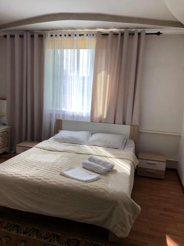 ein Schlafzimmer mit einem Bett mit zwei Handtüchern darauf in der Unterkunft Homestay JAISEL in Bischkek