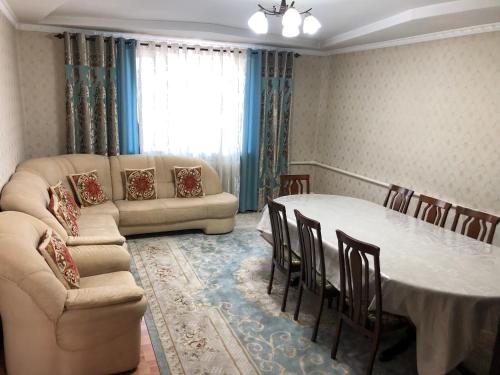 a living room with a table and a couch at Homestay JAISEL in Bishkek