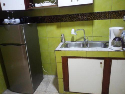 eine kleine Küche mit Spüle und Kühlschrank in der Unterkunft Arbre de Paix 40/1.1 in Douala