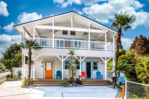 a white house with palm trees in front of it at THE VILLA SHARE in Hyuga