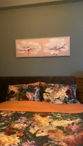 a bedroom with a bed with two pictures on the wall at m2 Tbilisi Central Park Apartment in Tbilisi City