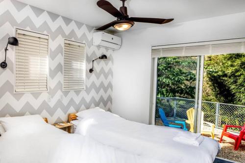 a bedroom with two beds and a ceiling fan at THE VILLA SHARE in Hyuga