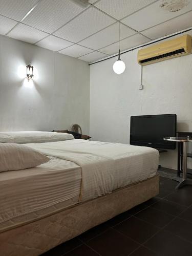 a bedroom with a large bed and a tv at G99 Hotel in George Town